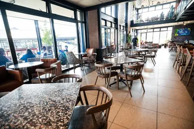 a restaurant with tables and chairs and windows at K47 propertyzz in Midrand