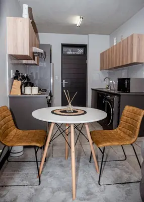 a kitchen with a white table and two chairs at K47 propertyzz in Midrand