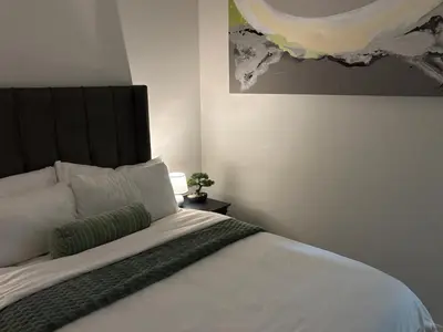 a bedroom with a large bed with a black headboard at Cozy nest apartment in Pretoria