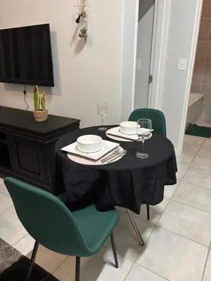 a dining room table with two chairs and a television at Cozy nest apartment in Pretoria