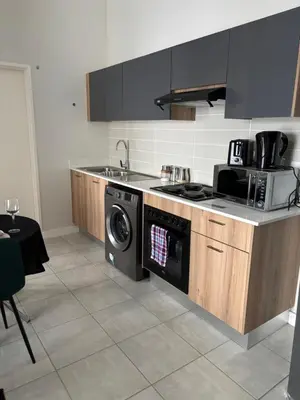 a kitchen with a stove and a washing machine at Cozy nest apartment in Pretoria