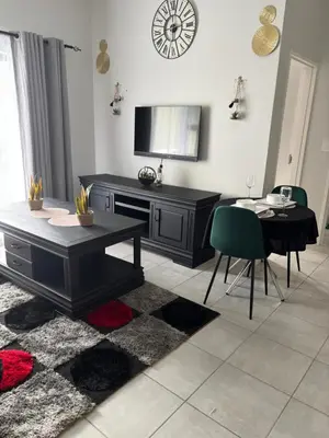 a living room with a table and a television at Cozy nest apartment in Pretoria