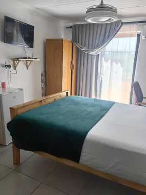 a bedroom with a large bed and a window at Sunset Hideaway in Pretoria