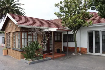 a brick house with a tree in front of it at Okuhlekwethu Guesthouse in Witbank