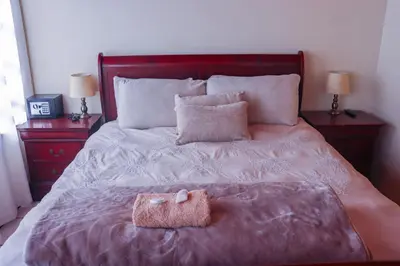 a bed with a purse on it with two night stands at Okuhlekwethu Guesthouse in Witbank