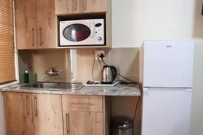 a small kitchen with a sink and a microwave at Okuhlekwethu Guesthouse in Witbank