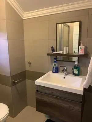 a bathroom with a sink and a mirror at Smartz Apartment Studio in Midrand