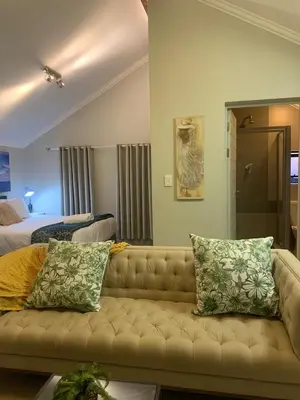 a living room with a couch and a bedroom at Smartz Apartment Studio in Midrand