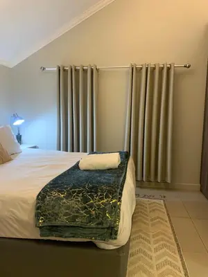 a bedroom with a bed with a blanket on it at Smartz Apartment Studio in Midrand
