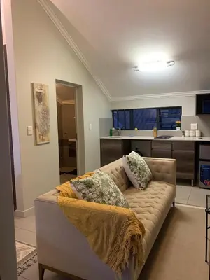 a living room with a couch and a kitchen at Smartz Apartment Studio in Midrand