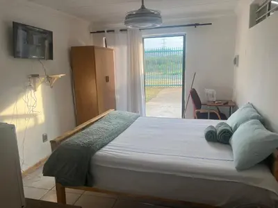 a bedroom with a bed and a sliding glass door at Sunset Hideaway in Pretoria