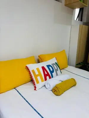 a bed with a happy pillow and towels on it at Sunset Hideaway in Pretoria