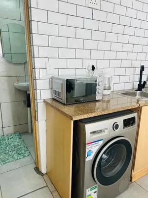 a microwave sitting on a counter next to a washing machine at Sunset Hideaway in Pretoria