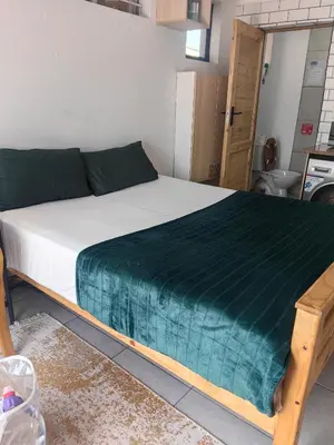 a bedroom with a bed with a green blanket on it at Sunset Hideaway in Pretoria