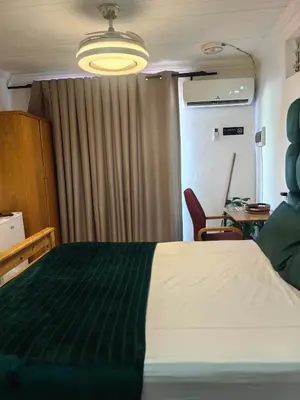 a bedroom with a bed and a desk and a window at Sunset Hideaway in Pretoria