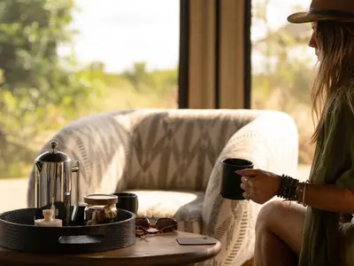 a woman sitting on a couch with a coffee table at Amaya in Hoedspruit