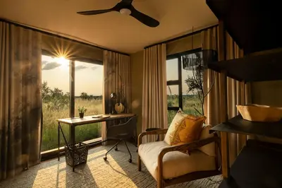 a living room with a couch and a table and a window at Amaya in Hoedspruit