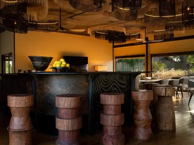 a bar with wooden stools in a restaurant at Amaya in Hoedspruit