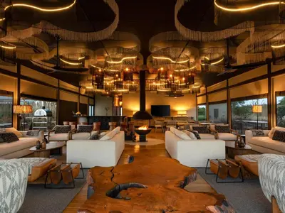 a living room with white furniture and a large table at Amaya in Hoedspruit