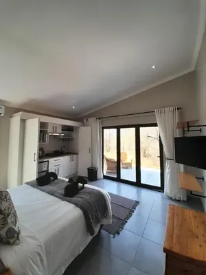 a bedroom with a large bed and a large window at Chikunda Hayes in Marloth Park