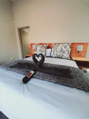 a bed with a black towel in the shape of a heart at Chikunda Hayes in Marloth Park
