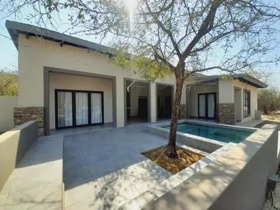 a house with a swimming pool and a tree at Krugers elegant escape The Kop in Marloth Park