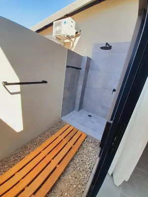 a shower in a room with a wooden bench at Krugers elegant escape The Kop in Marloth Park
