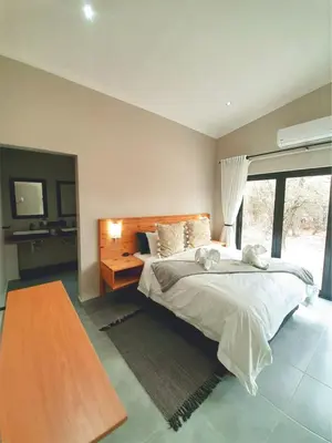 a bedroom with a large bed and a large window at Krugers elegant escape The Kop in Marloth Park