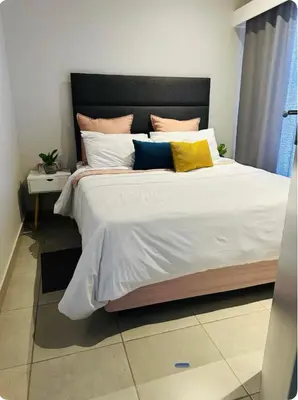 a bedroom with a large white bed with pillows at Serenity stay in Kempton Park