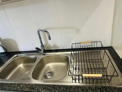 a kitchen sink with a dish drying rack on it at Serenity stay in Kempton Park