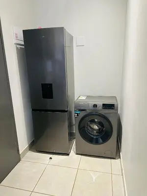 a refrigerator and a washing machine in a room at Serenity stay in Kempton Park