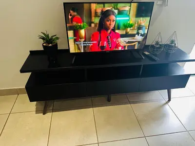 a television sitting on top of a black dresser at Serenity stay in Kempton Park