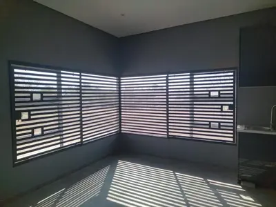 a room with two large windows with blinds at 114 zinnia place in Midrand