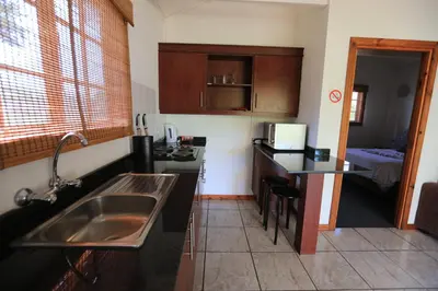a small kitchen with a sink and a table at Kruger View Chalets in Malelane