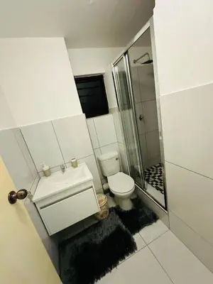 a small bathroom with a toilet and a shower at 2 Bedrooms Apartment - Hartbeespoort Dam in Hartbeespoort