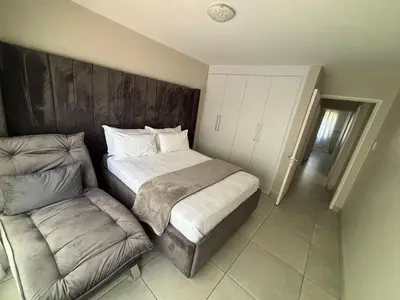 a bedroom with a bed and a couch in it at 2 Bedrooms Apartment - Hartbeespoort Dam in Hartbeespoort
