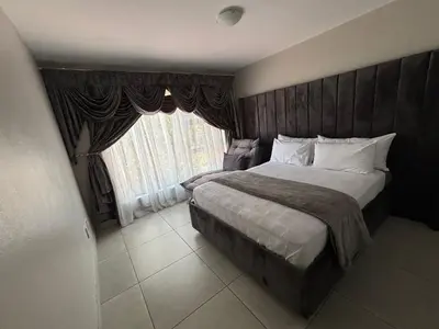 a bedroom with a large bed and a window at 2 Bedrooms Apartment - Hartbeespoort Dam in Hartbeespoort