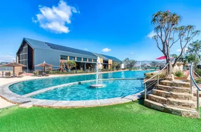 a swimming pool with a fountain in front of a building at Stay easy at green creek in Pretoria