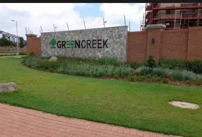 a sign on the side of a brick building at Stay easy at green creek in Pretoria