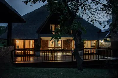 a house with a fence in front of it at DUBE SAFARI LODGE at Kruger Park Lodge 505 in Hazyview