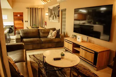 a living room with a couch and a table at DUBE SAFARI LODGE at Kruger Park Lodge 505 in Hazyview
