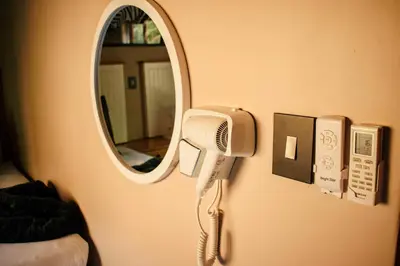 a hair dryer on a wall with a mirror at DUBE SAFARI LODGE at Kruger Park Lodge 505 in Hazyview
