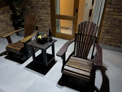 two wooden chairs and a table with a bowl of flowers at DUBE SAFARI LODGE at Kruger Park Lodge 505 in Hazyview