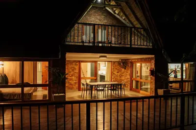 a house with a table and chairs at night at DUBE SAFARI LODGE at Kruger Park Lodge 505 in Hazyview