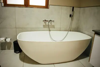 a white bath tub in a bathroom with a window at DUBE SAFARI LODGE at Kruger Park Lodge 505 in Hazyview