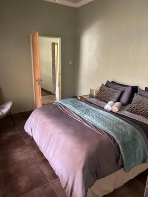 a bedroom with a large bed with purple sheets and pillows at Lulus bistro in Middelburg