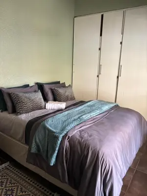 a bedroom with a large bed with purple sheets and pillows at Lulus bistro in Middelburg
