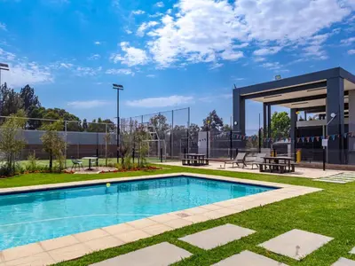 a swimming pool in a park with a building at Glen Haven in Midrand