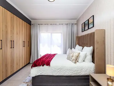 a bedroom with a large bed and a window at Glen Haven in Midrand