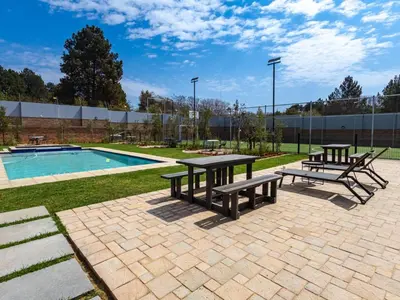 a picnic table and benches next to a pool at Glen Haven in Midrand